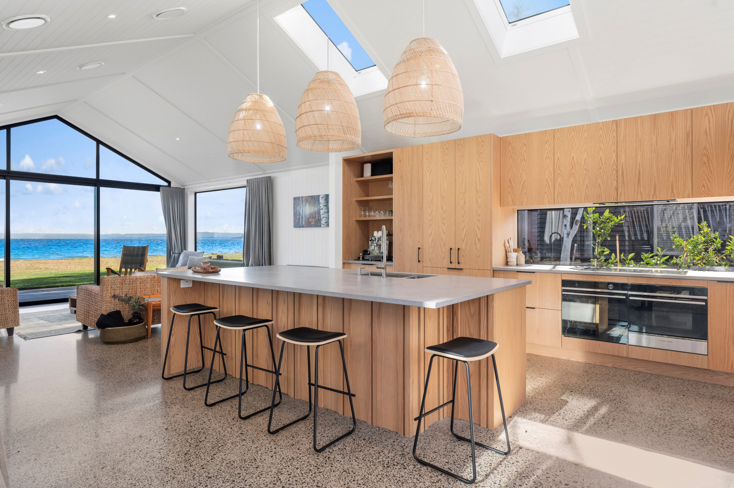 The window creates a splash-back and beautiful view of the garden. This brings light and colour in to this design and build home.